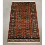 A modern Pakistani wool on cotton rug, brown geometric design, 160cm x 94cm