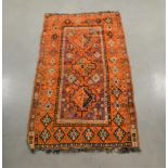 A wool on wool rug, orange and purple geometric pattern, fringes, with some wear, AF, 178cm x 101