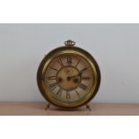 An Ansonia Clock Company American copper and brass circular clock, raised on two feet with a
