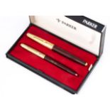 A Parker fountain pen and biro pen set, boxed, maroon barrels and gilt caps, marked Air India,