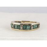 A 14k marked emerald and diamond dress ring, oval mixed cut emeralds alternately set with pairs of