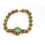 A continental yellow metal and bowenite bracelet, the oval cabochons, on collet settings,