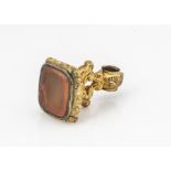 A pinch beck and carnelian fob seal, of scroll and cushion shape, with rectangular panel to