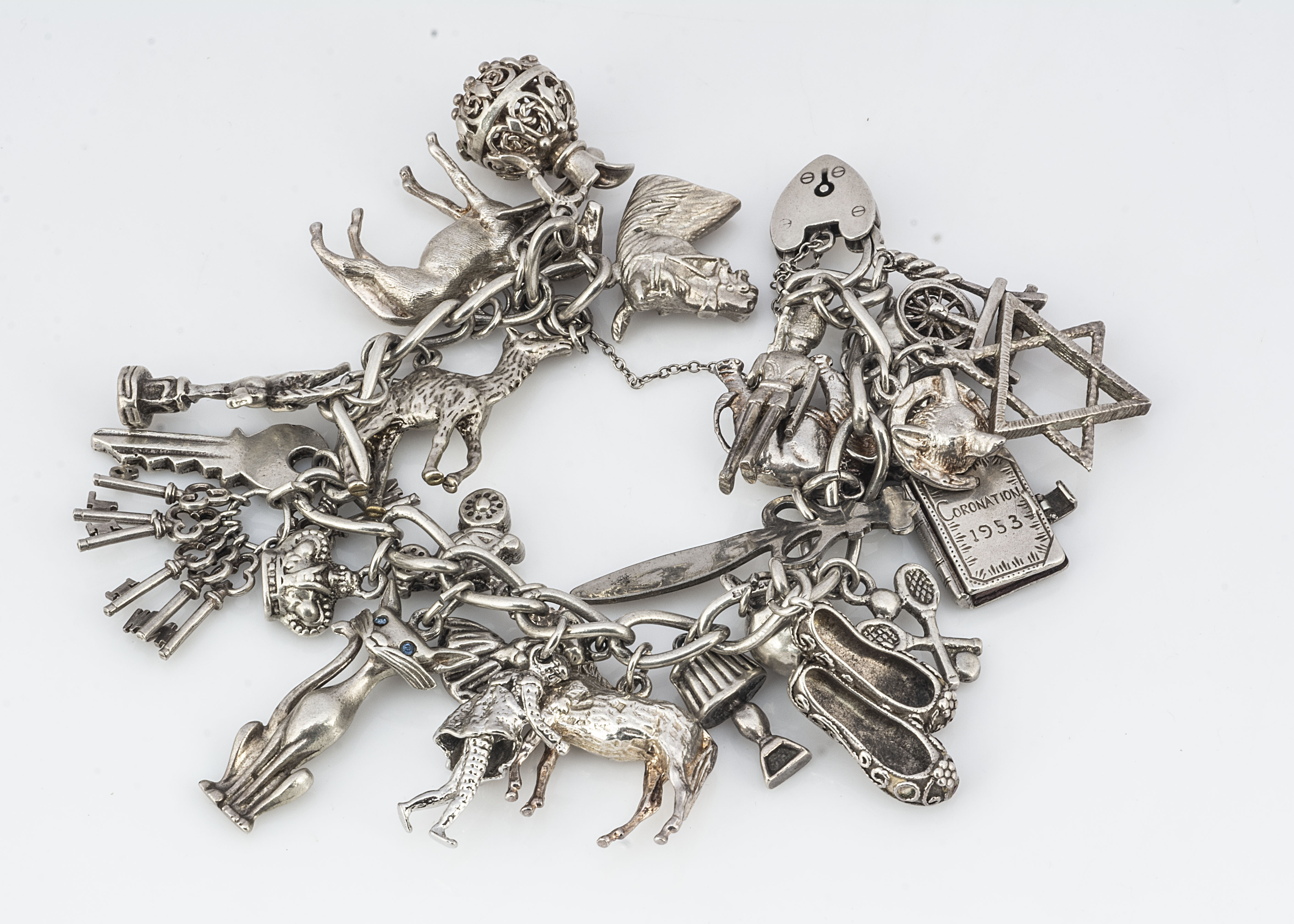 A silver charm bracelet, with multiple charms, including horses, keys, elephants, etc, 110g