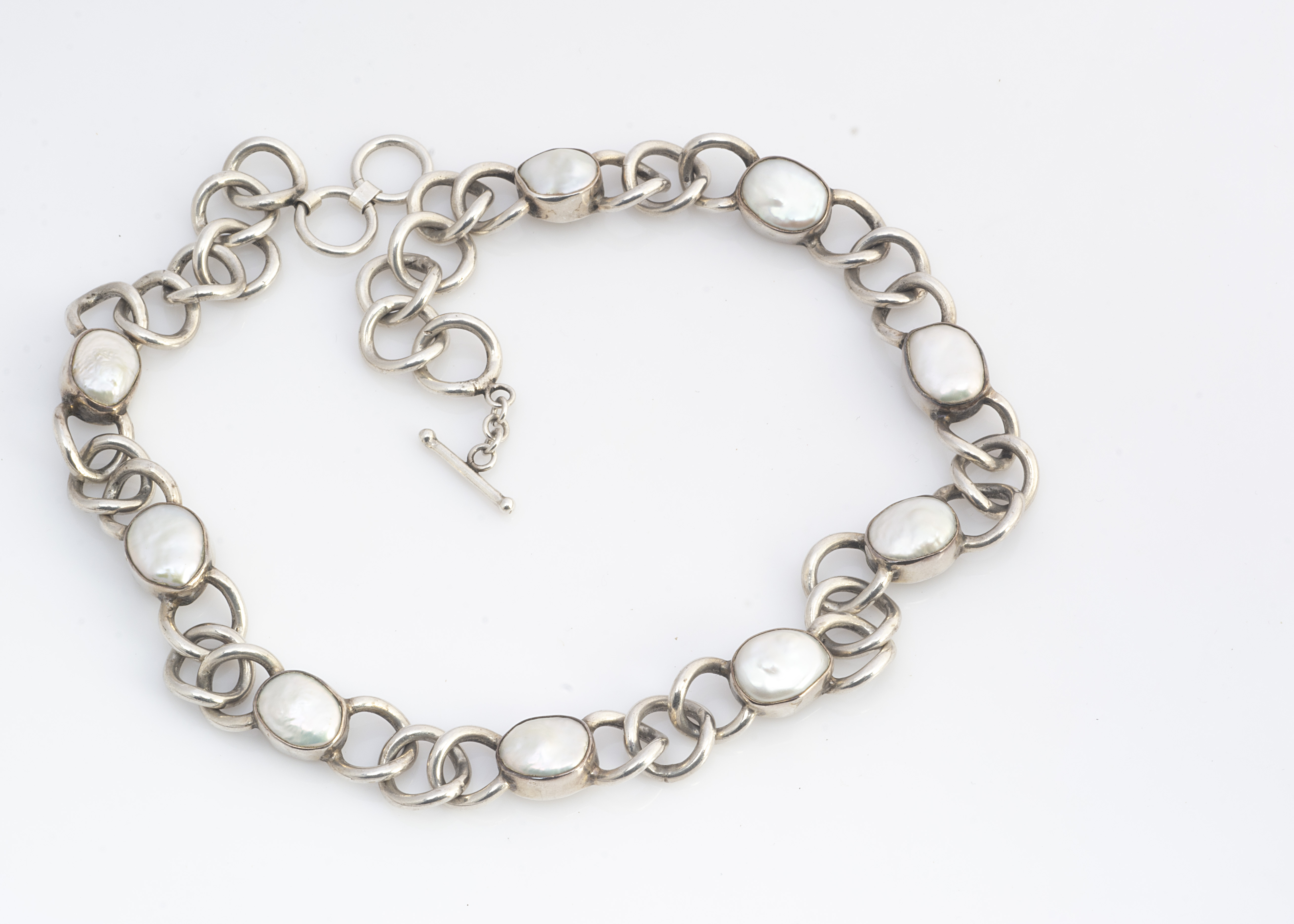 An Arts and Crafts style silver and mother of pearl necklace, the curb links alternately set with