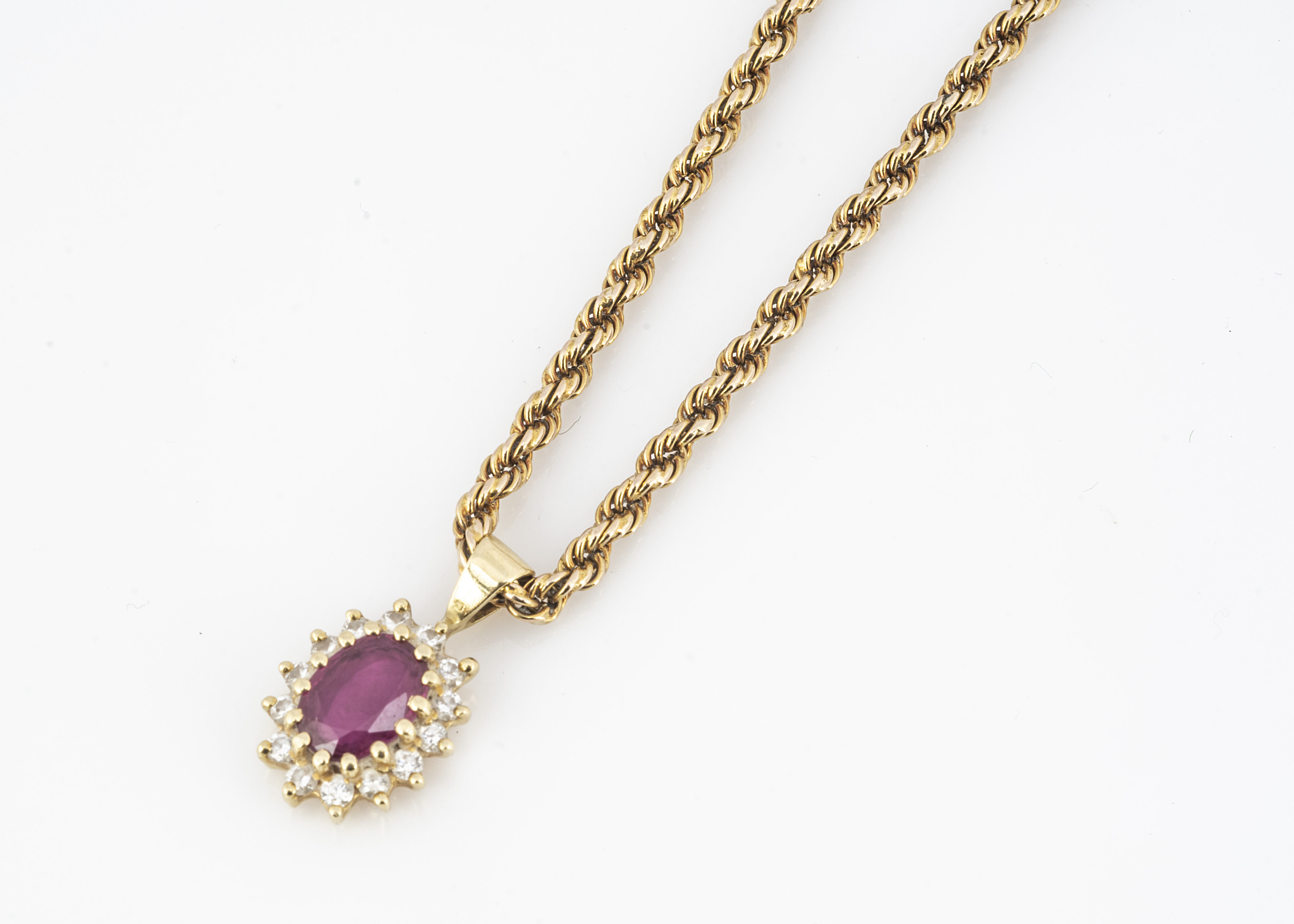 An 18ct gold ruby and diamond oval drop pendant, on a 9ct gold rope twist chain, 24cm together, 9.8g