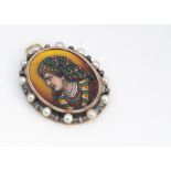 An Indian enamel oval yellow metal pendant, the oval panel with painted profile of a young woman