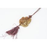 A Chinese hardstone panel pendant, with pierced form of elder and goat, on a burgundy silk cord with