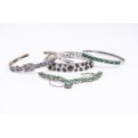 A silver diamond and tanzanite bangle, an emerald bangle in silver an emerald fringe necklace in