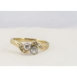 An 18ct gold diamond cross over dress ring, the brilliant cuts in claw set, with diamond