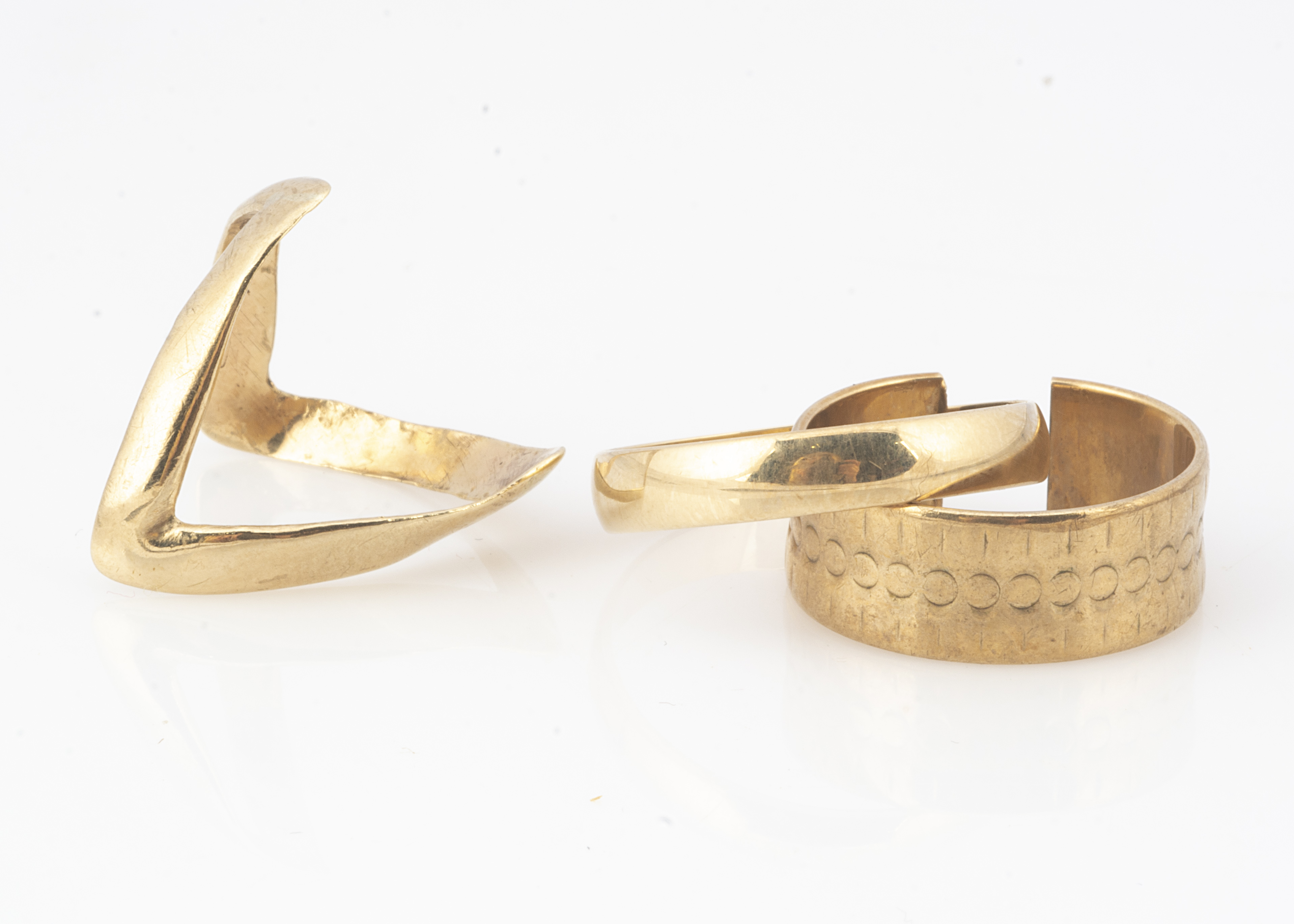 Three 9ct gold bands, including a wishbone example, ring size O, a wedding band, ring size V and