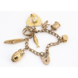 A 9ct gold curb link charm bracelet, with padlock clasp, having eight charms including an owl,