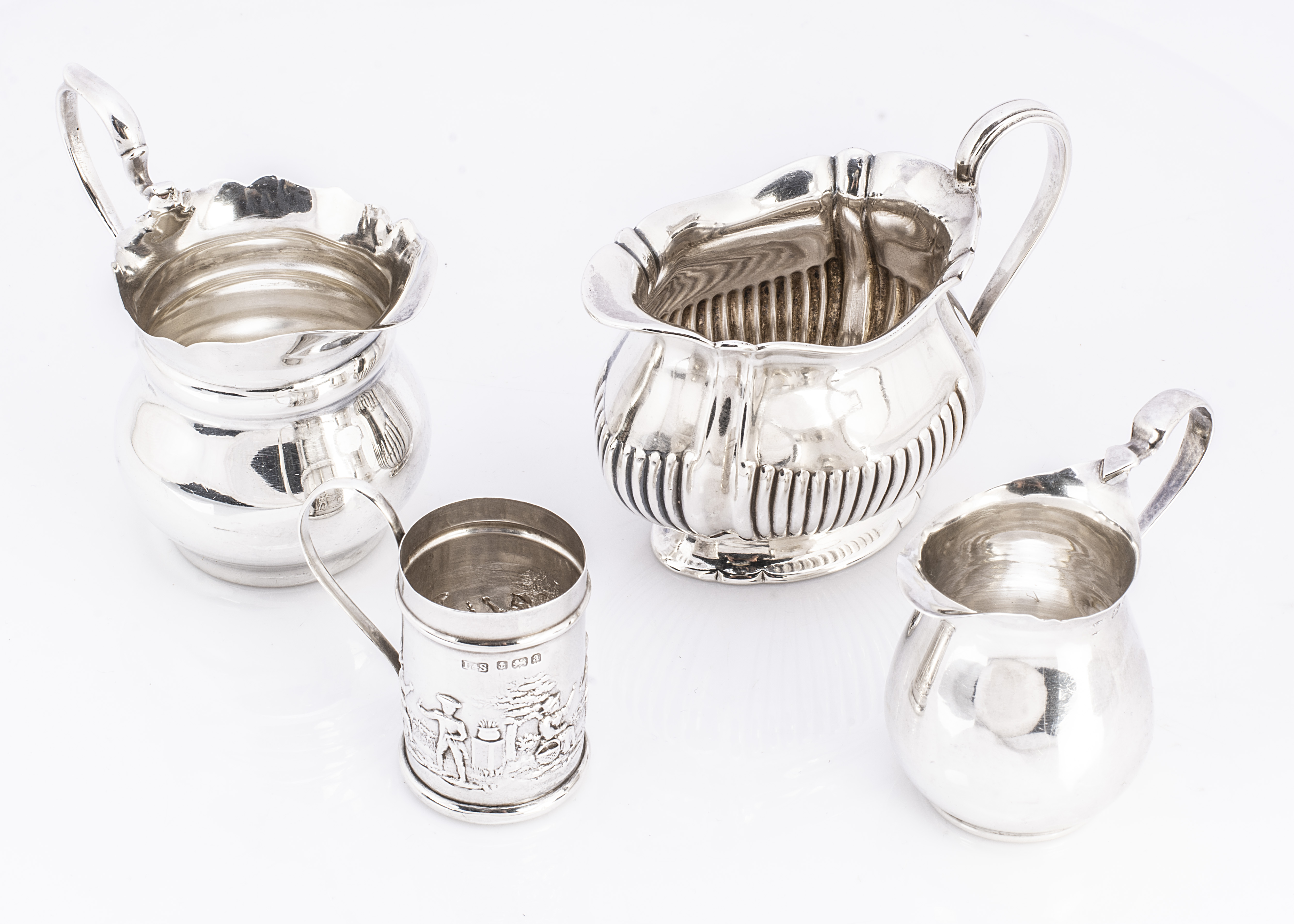 Four Victorian and later small items of silver, including three jugs and a miniature tankard, 6.8