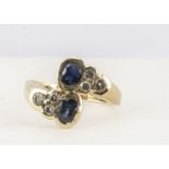 A 14ct sapphire and diamond dress ring, oval mixed cut sapphires in a cross over setting with