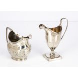 Two Georgian silver milk jugs, one helmet shaped with square base and engraved initials, possibly