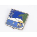 An Art Deco enamel and base metal Ajaccio Corsican brooch, decorated with a yacht within a