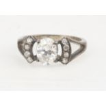 An Edwardian style paste set dress ring, the oval mixed cut flanked by paste set shoulders, ring