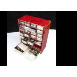 A useful collection of watch repairer's spare parts, in a multi-drawer unit containing winders,