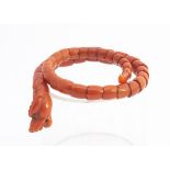 A 19th Century Chinese coral carved articulated dragon bangle, with carved dragon's head, scaled