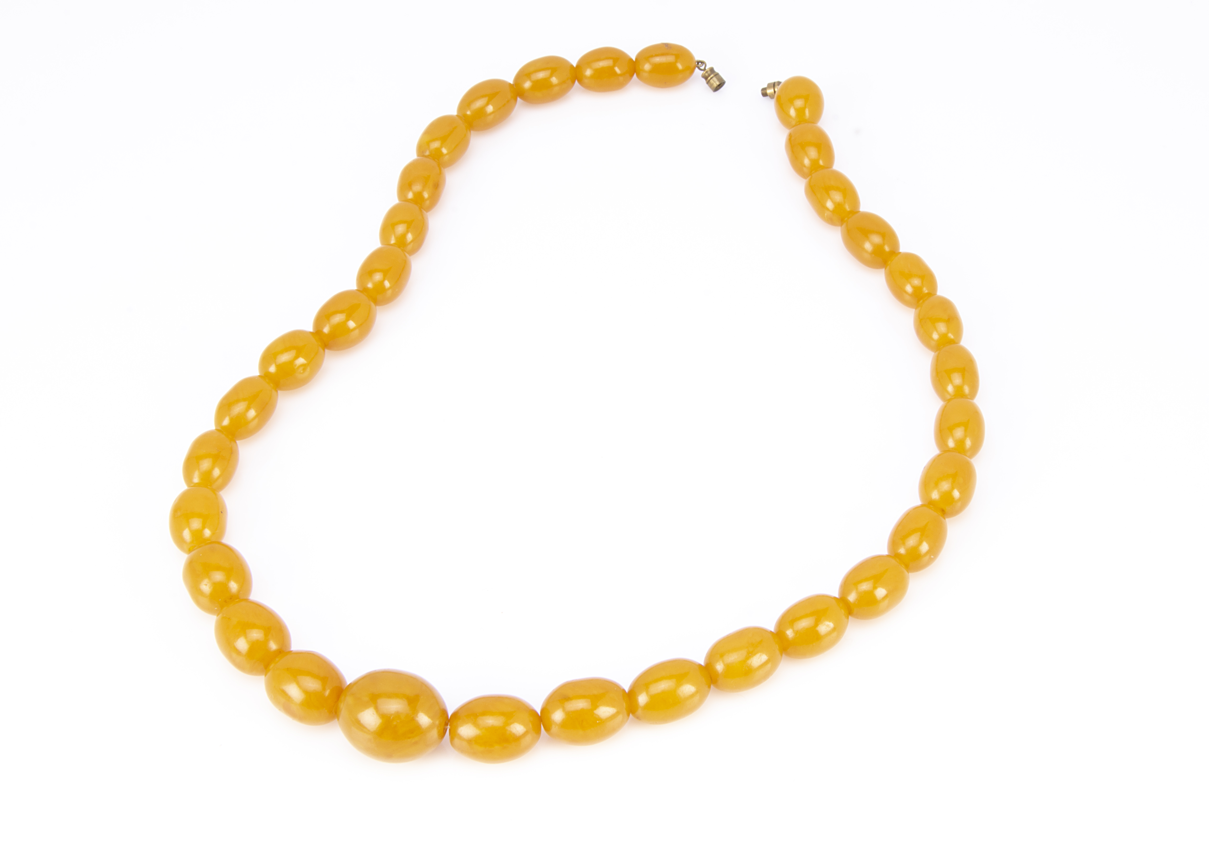 A string of graduated pressed amber oval beads, largest 2.5cm, smallest 1.8cm, 30.5cm together, 94g