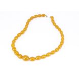 A string of graduated pressed amber oval beads, largest 2.5cm, smallest 1.8cm, 30.5cm together, 94g