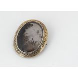 A 19th Century moss agate oval brooch, the polished moss agate panel within an oval gold frame