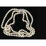 A three strand cultured pearl necklace, with sapphire and diamond clasp, the uniform knotted