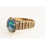 A 9ct gold and opal doublet dress ring, with textured flank with opal doublet top, ring size O, 4g