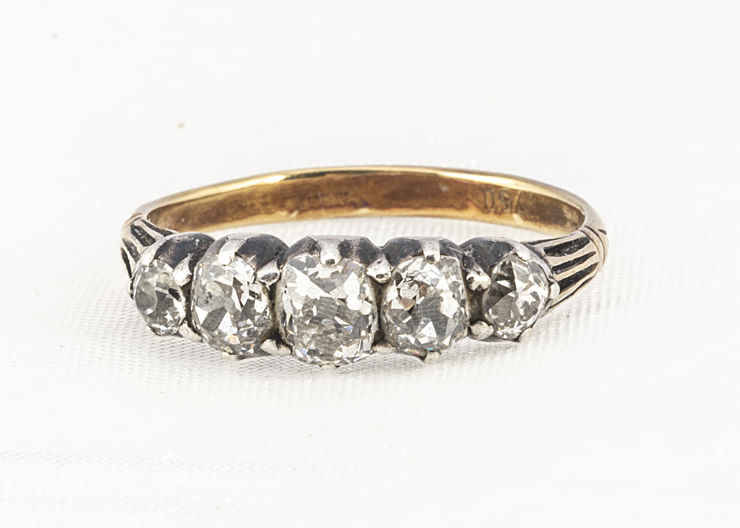 A five stone antique diamond dress ring, the cushion cuts mounted in silver on a later shank