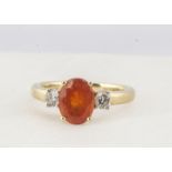 An 18ct gold three stone fire opal and diamond ring, the oval mixed cut opal in four claw setting,