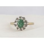 A 9ct emerald and diamond oval cluster ring, mixed oval cut emerald in claw setting surrounded by