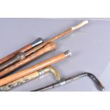 A group of seven walking sticks and canes, to include one with silver top, one with plated top,