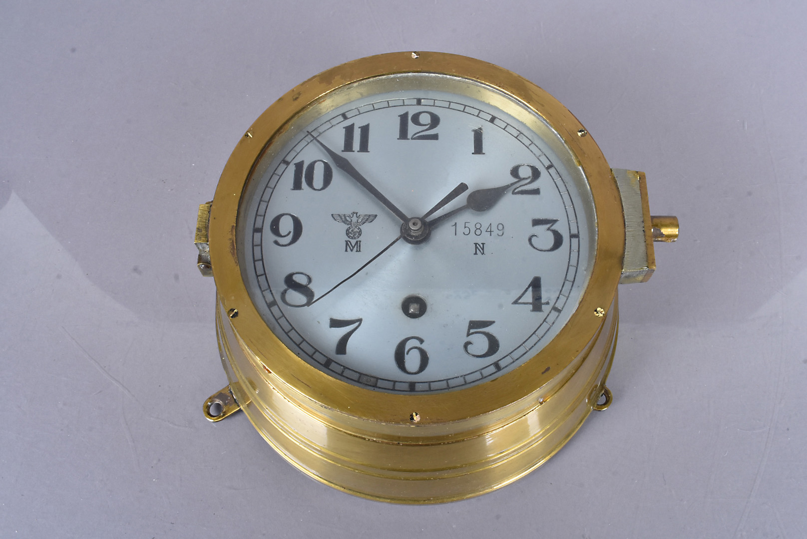 A Third Reich Kriegsmarine Bulkhead clock, in brass, with silvered 14.5cm diameter dial, with