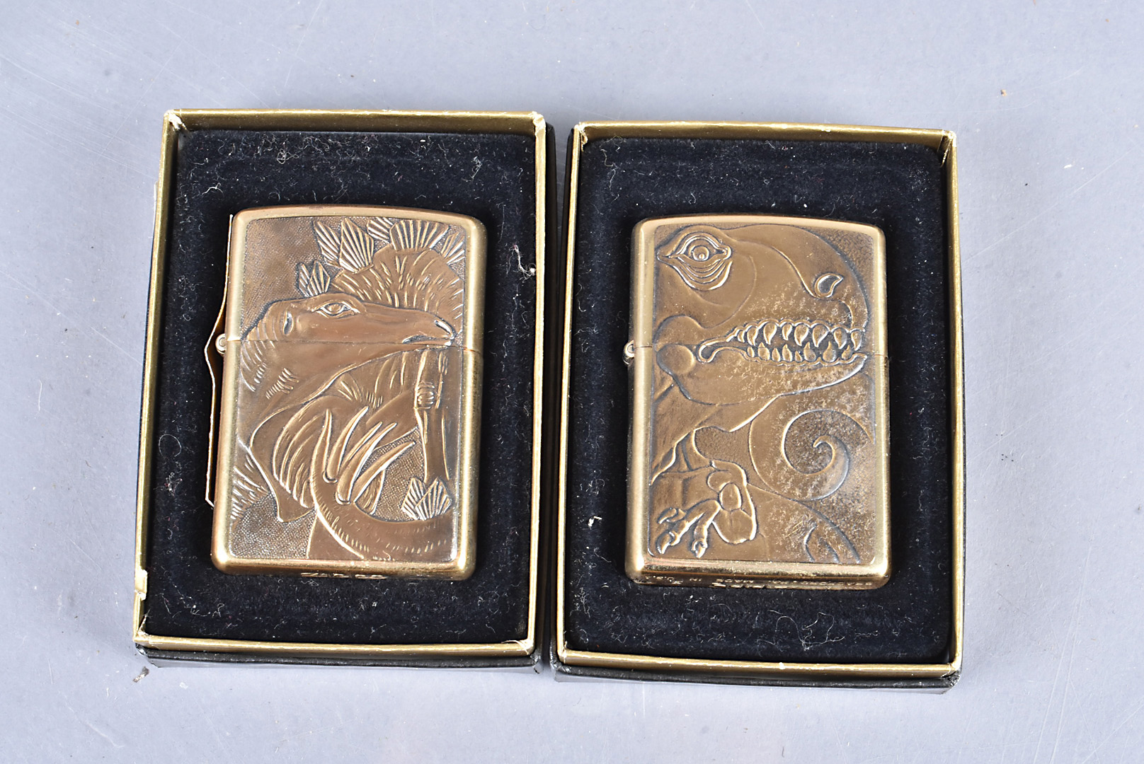 Dinosaurs, two Zippo lighters by Barrett Smythe, comprising a 1994 Tyrannosaurus Rex, and a 1995