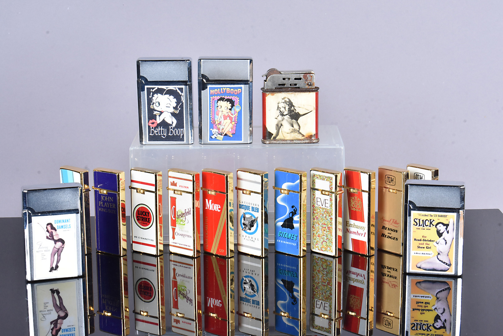 An assortment of Penguin Sharp pocket lighters, advertising numerous cigarette brands, including