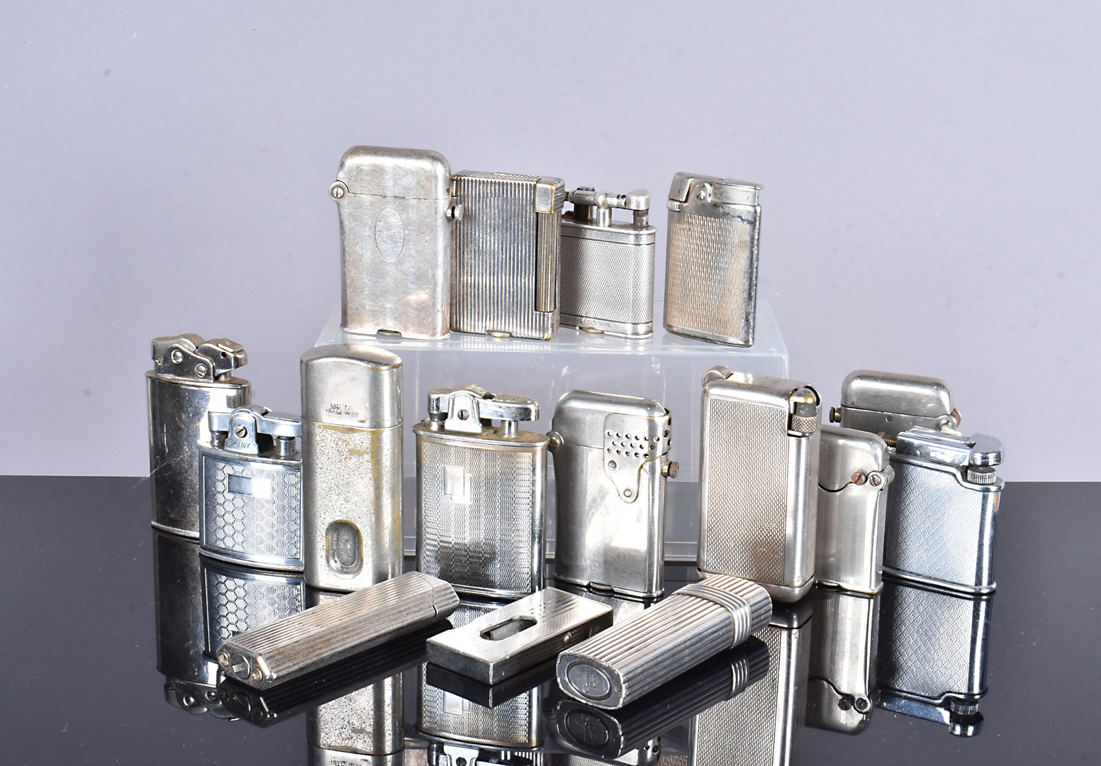 A collection of plated and white metal lighters, including Christian, Dior, Thorens, Dunhill,