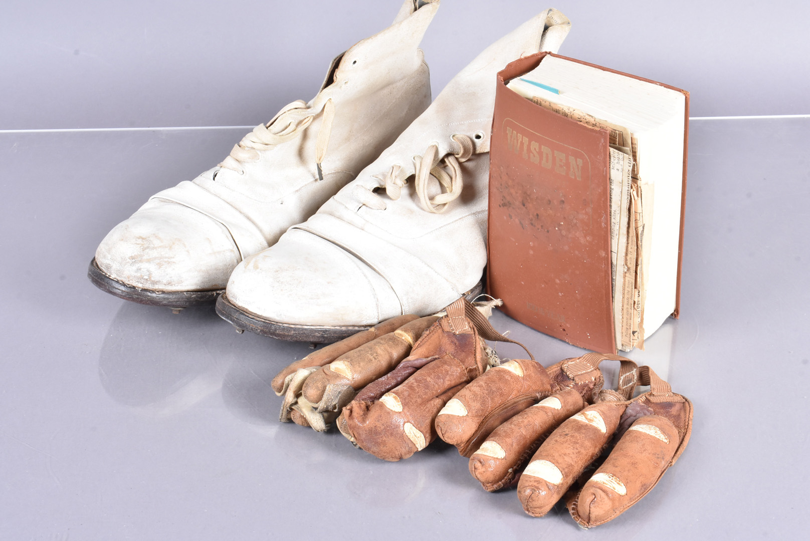 A small collection of cricket items, to include a pair of white cricket shoes, a pair of gloves,