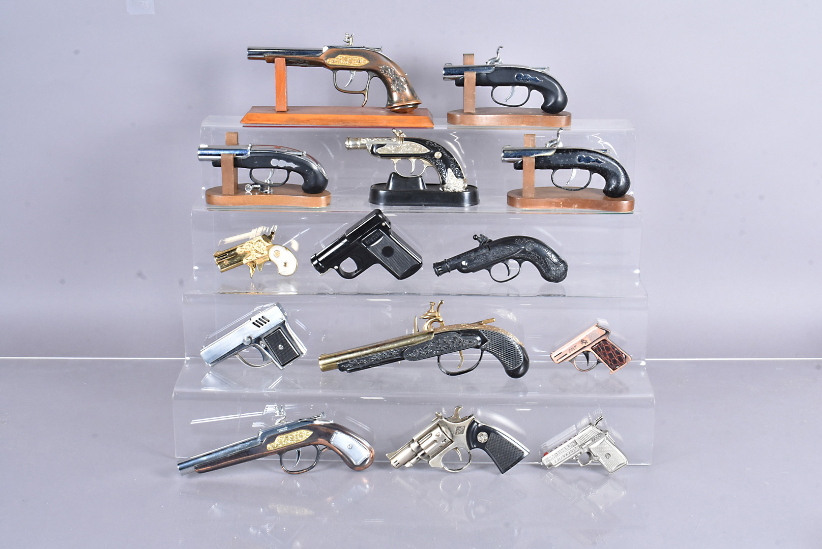 A collection of novelty gun pocket and table lighters, in the form of flintlock pistols,