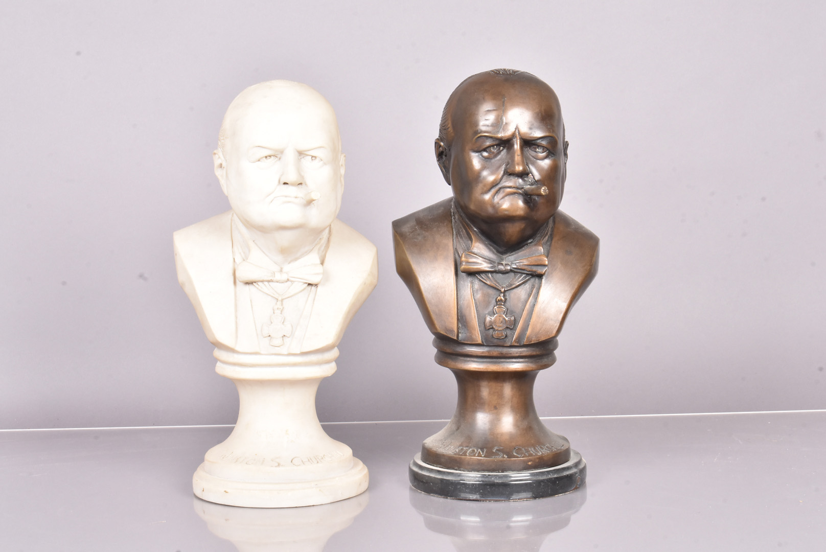 A pair of unnamed busts of Winston S. Churchill, one in bronze, the other in marble, both with his