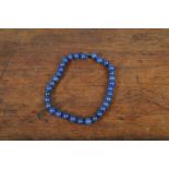 A string of lapis lazuli spherical beads, uniform, knotted strung with silver clasp, 45 cm max