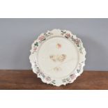 An 18th century salt glazed shaped plate, with painted floral decoration to border and insects and