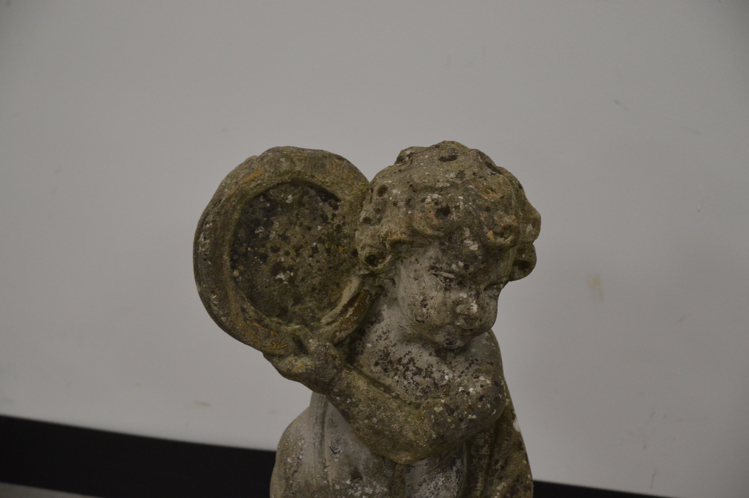 A cast garden cherub, of moulded form, holding a harp. 71 cm tall. Some wear and weathering. AF (1) - Image 2 of 2