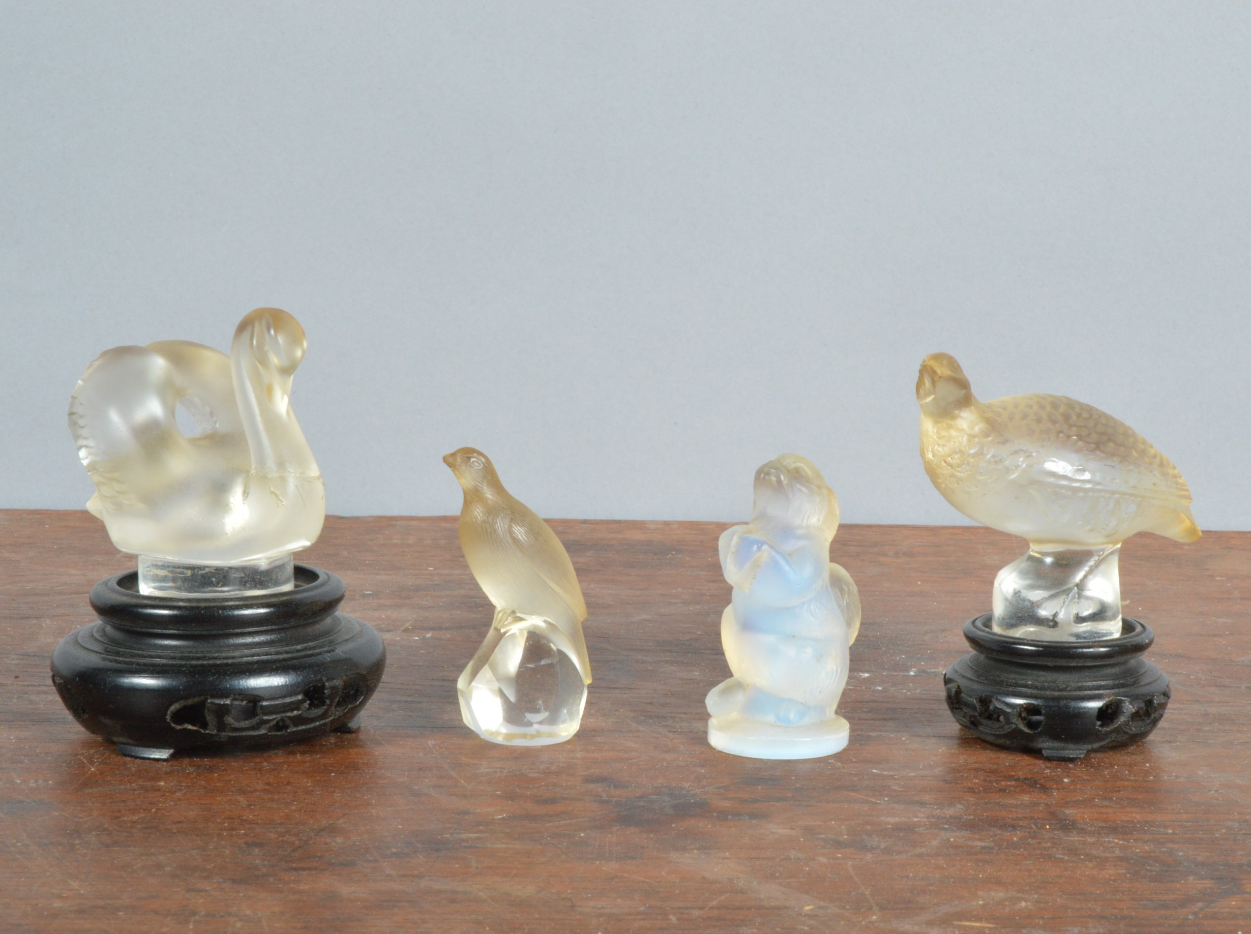 A Lalique France swan, 5.5cm x 5.5cm (excluding the stand), the neck cracked and repaired, together