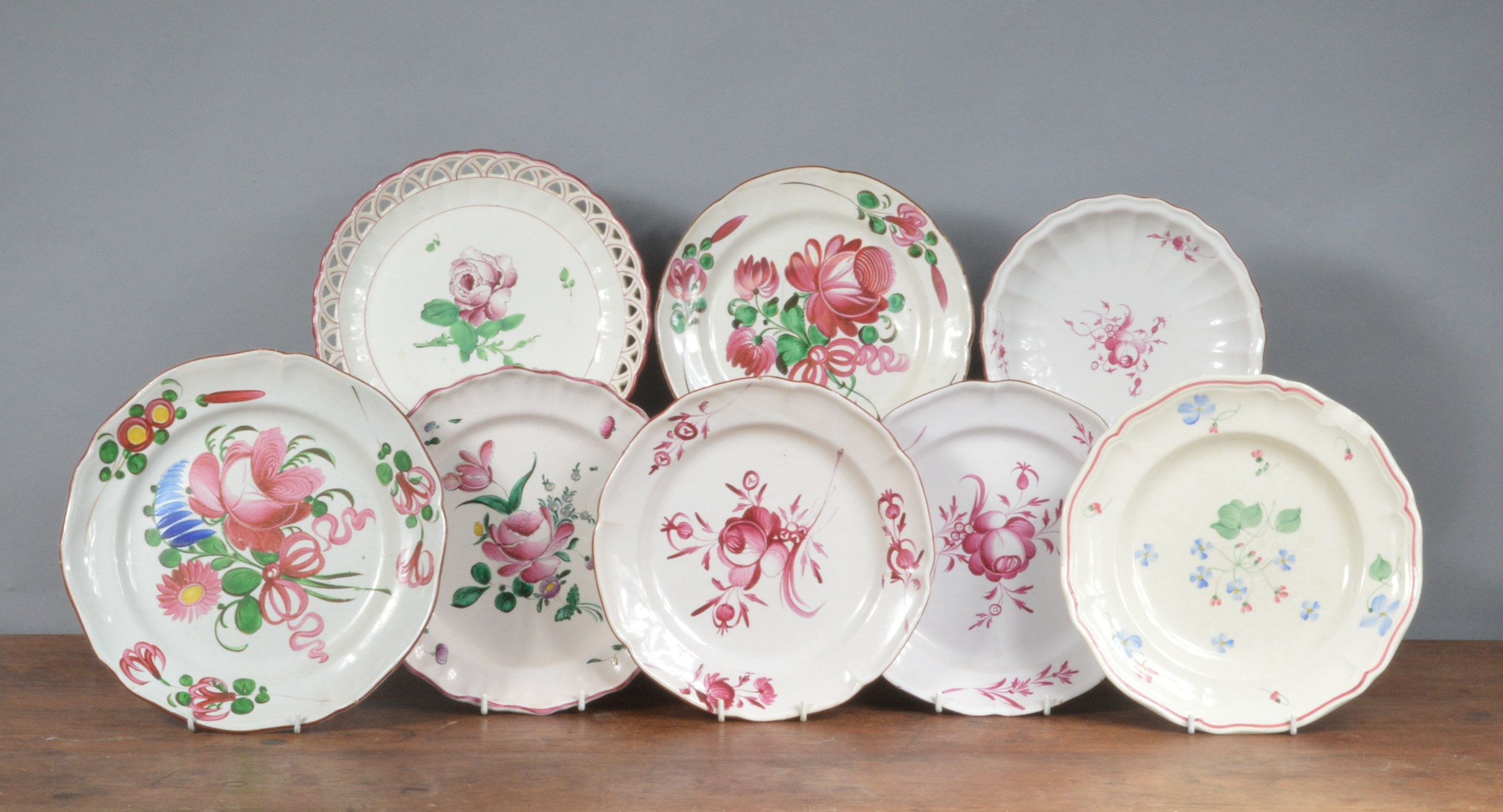 A group of mainly French 19th century faience plates, each decorated with floral designs. 23 - 25 cm