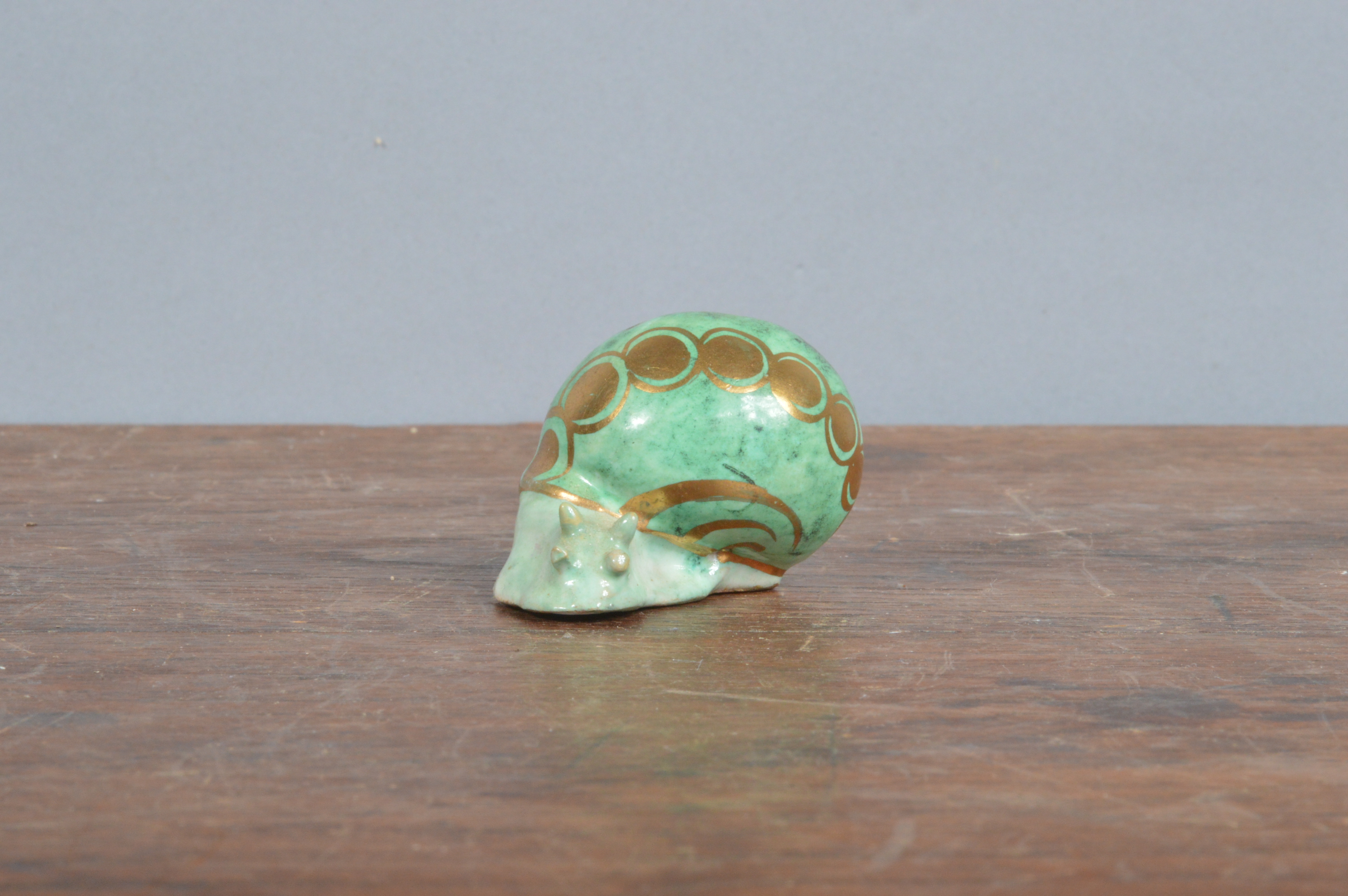 An early 20th century French Bruneau Balon Blois faience snail, green glaze with heightened gilt,