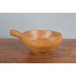 A 19th century elm treen primitive handled bowl, some wear commensurate with age and use, 35cm