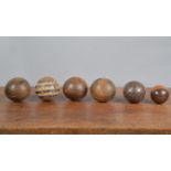 A collection of 19th century hand carved carpet boules, the majority wooden, one resin, the largest,