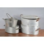 Three large metal twin handled cooking pots, with covers, the largest 43cm in length, together with