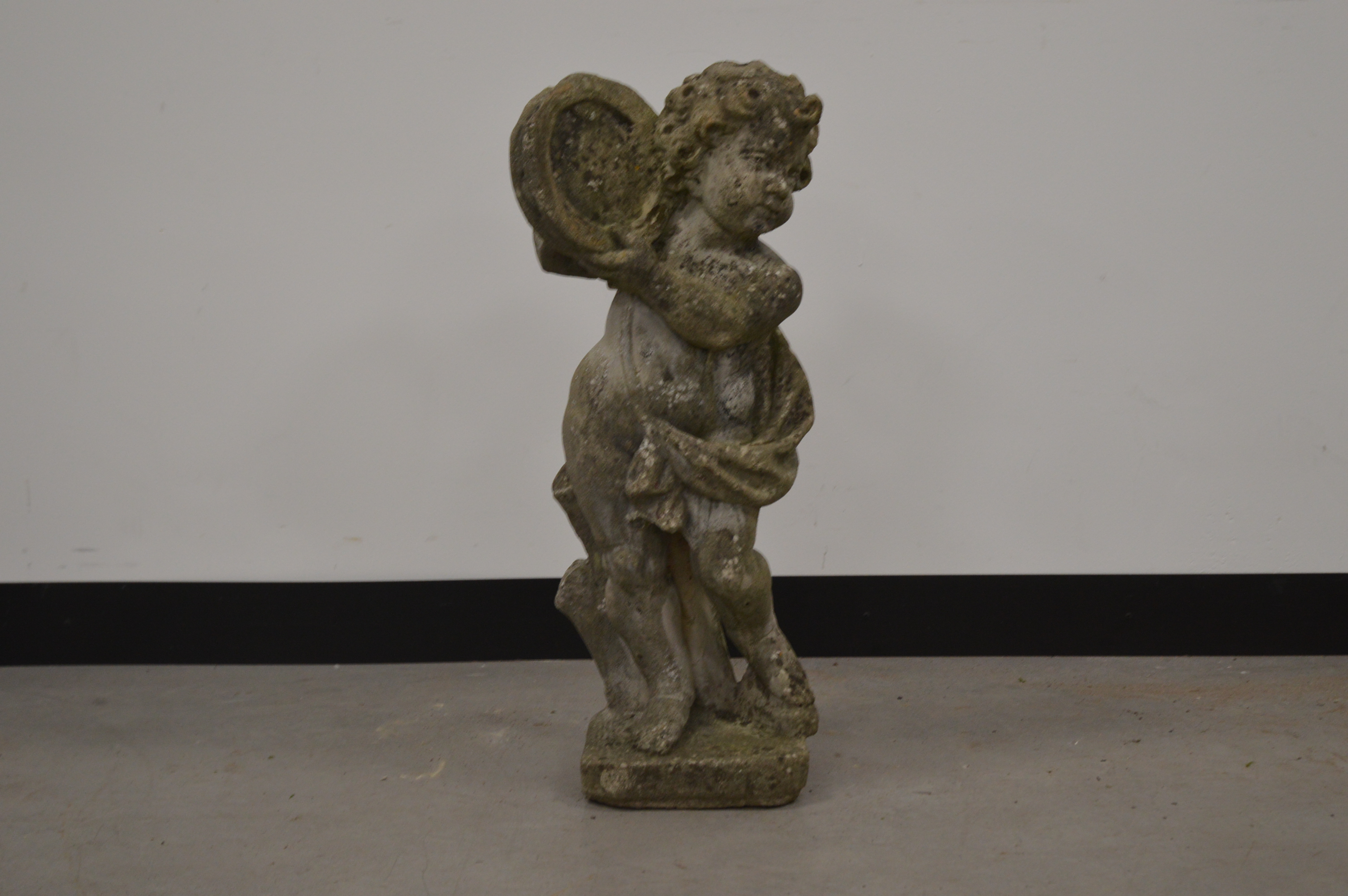 A cast garden cherub, of moulded form, holding a harp. 71 cm tall. Some wear and weathering. AF (1)