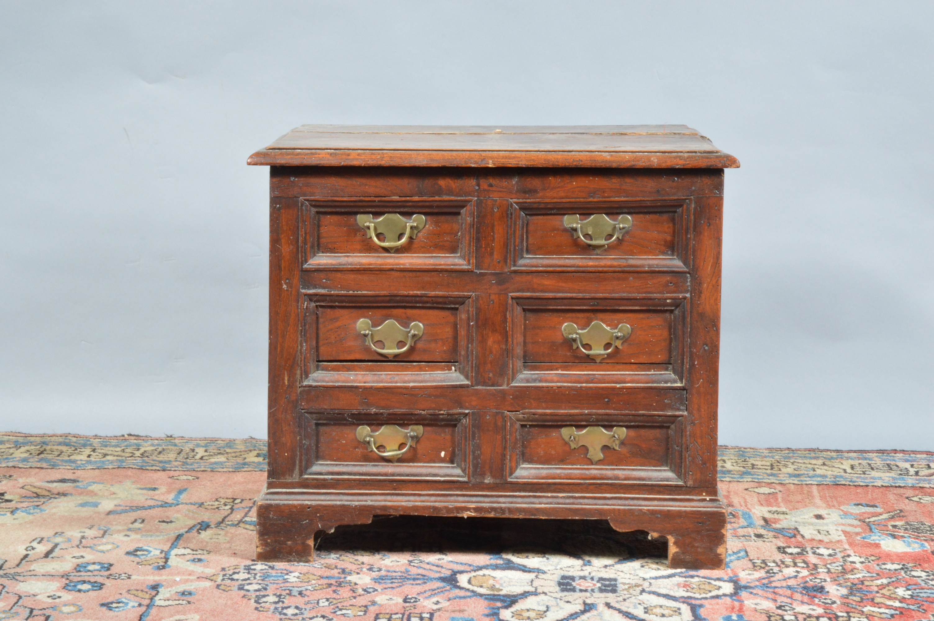 A 19th century elm storage box, lift open lid (cracked), faux draw front with brass handles, with